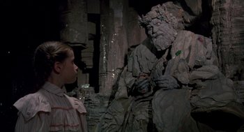 Movie still from “Return to Oz” (1985), directed by Walter Murch – A woman and a statue of a man sitting in a cave; Medium shot, Over the shoulder angle
