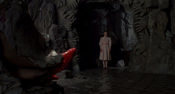 Movie still from “Return to Oz” (1985), directed by Walter Murch – A woman standing in front of an entrance to a cave; Wide shot, Low angle