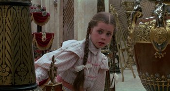 Movie still from “Return to Oz” (1985), directed by Walter Murch – A young girl with long braids standing in a room; Medium shot, Over the shoulder angle