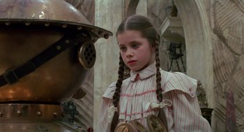 Movie still from “Return to Oz” (1985), directed by Walter Murch – A young girl in a striped dress looking at a man in a helmet; Close Up shot, Over the shoulder angle