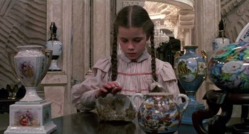 Movie still from “Return to Oz” (1985), directed by Walter Murch – A young girl sitting at a table looking at a vase; Close Up shot, High angle