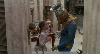 Movie still from “Return to Oz” (1985), directed by Walter Murch – A person dressed as a scarecrow talking to a girl; Medium shot, Over the shoulder angle