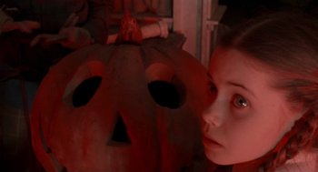 Movie still from “Return to Oz” (1985), directed by Walter Murch – A young girl standing in front of a carved pumpkin; Close Up shot, High angle