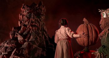Movie still from “Return to Oz” (1985), directed by Walter Murch – A woman standing in front of a tree with a basket; Medium shot, Low angle