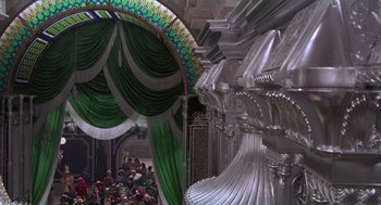 Movie still from “Return to Oz” (1985), directed by Walter Murch – A room filled with lots of people and green curtains on the ceiling; Extreme Wide shot, Low angle