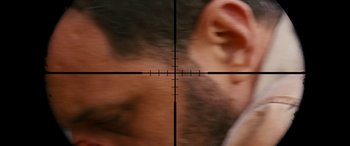 Movie still from “Revenge” (2017), directed by Coralie Fargeat – A man's ear is seen through a rifle scope; Extreme Close Up shot, Over the shoulder angle
