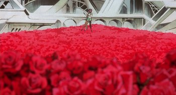 Movie still from “Revolutionary Girl Utena: The Movie” (1999), directed by Katsushi Sakurabi – A man standing on top of a bed of red roses; Extreme Wide shot, High angle