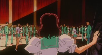 Movie still from “Revolutionary Girl Utena: The Movie” (1999), directed by Katsushi Sakurabi – A woman is standing in front of a group of people; Extreme Wide shot, High angle