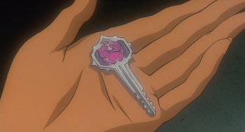 Movie still from “Revolutionary Girl Utena: The Movie” (1999), directed by Katsushi Sakurabi – A hand is holding a key with a rose on it; Extreme Close Up shot, High angle