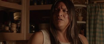 Movie still from “Rhymes for Young Ghouls” (2013), directed by Jeff Barnaby – A person with long hair and a white shirt; Close Up shot, Over the shoulder angle