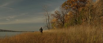 Movie still from “Rhymes for Young Ghouls” (2013), directed by Jeff Barnaby – A man standing in a field with trees in the background; Extreme Wide shot, High angle