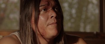 Movie still from “Rhymes for Young Ghouls” (2013), directed by Jeff Barnaby – A person with long brown hair; Close Up shot, Over the shoulder angle