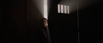 Movie still from “Rhymes for Young Ghouls” (2013), directed by Jeff Barnaby – A young child standing in a dark room; Medium shot, Low angle