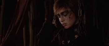 Movie still from “Rhymes for Young Ghouls” (2013), directed by Jeff Barnaby – A person with makeup on talking on a cell phone; Close Up shot, Over the shoulder angle