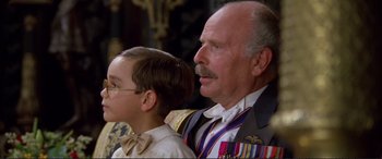 Movie still from “Richard III” (1995), directed by Richard Loncraine – A man and a young boy wearing medals; Close Up shot, Low angle