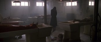 Movie still from “Richard III” (1995), directed by Richard Loncraine – A woman standing in a kitchen in the fog; Wide shot, High angle
