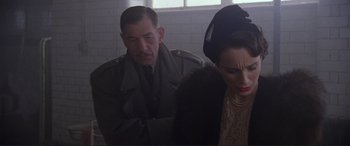 Movie still from “Richard III” (1995), directed by Richard Loncraine – A man and a woman sitting next to each other in a room; Close Up shot, Over the shoulder angle