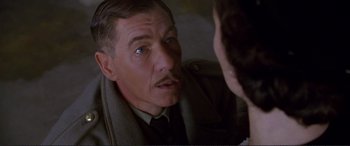 Movie still from “Richard III” (1995), directed by Richard Loncraine – An older man wearing a suit and tie looking at the camera; Close Up shot, Over the shoulder angle