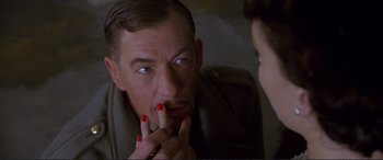 Movie still from “Richard III” (1995), directed by Richard Loncraine – A man with red fingernails is looking at his reflection in a mirror; Close Up shot, Over the shoulder angle