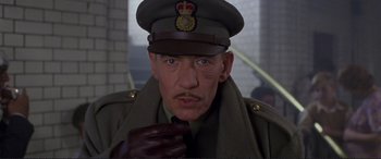 Movie still from “Richard III” (1995), directed by Richard Loncraine – An older man wearing a uniform and a hat; Close Up shot, Low angle