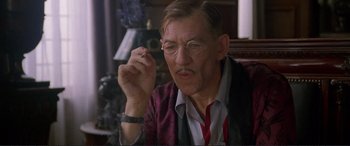 Movie still from “Richard III” (1995), directed by Richard Loncraine – An older man smoking a cigarette while wearing glasses; Close Up shot, Low angle