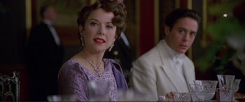 Movie still from “Richard III” (1995), directed by Richard Loncraine – A woman in a purple dress and a white suit; Close Up shot, Over the shoulder angle