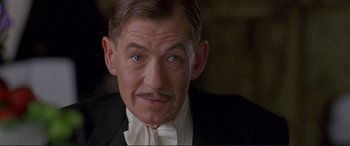 Movie still from “Richard III” (1995), directed by Richard Loncraine – An older man wearing a white shirt and a black suit; Close Up shot, Low angle