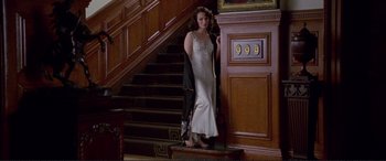 Movie still from “Richard III” (1995), directed by Richard Loncraine – A woman in a white dress standing on the stairs; Wide shot, High angle