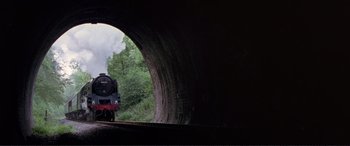 Movie still from “Richard III” (1995), directed by Richard Loncraine – A train traveling down train tracks through a tunnel; Extreme Wide shot, Low angle