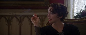 Movie still from “Richard III” (1995), directed by Richard Loncraine – A woman holding a cigarette in her hand; Close Up shot, Over the shoulder angle