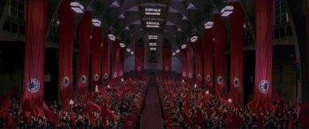 Movie still from “Richard III” (1995), directed by Richard Loncraine – A large audience is sitting in a large auditorium; Extreme Wide shot, High angle