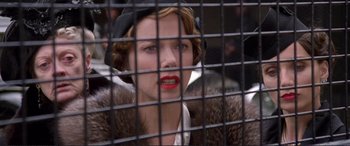 Movie still from “Richard III” (1995), directed by Richard Loncraine – A woman with red lipstick looking through a fence; Close Up shot, Low angle