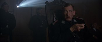 Movie still from “Richard III” (1995), directed by Richard Loncraine – A man in a uniform standing in front of a mirror; Medium shot, Low angle