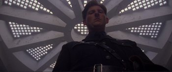 Movie still from “Richard III” (1995), directed by Richard Loncraine – A man in a uniform standing in front of a building; Close Up shot, Low angle