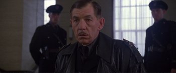 Movie still from “Richard III” (1995), directed by Richard Loncraine – An older man wearing a black leather jacket; Close Up shot, Low angle