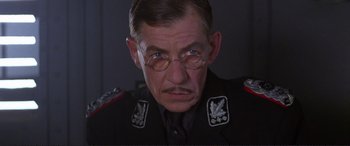 Movie still from “Richard III” (1995), directed by Richard Loncraine – An older man wearing a uniform and glasses; Close Up shot, Low angle
