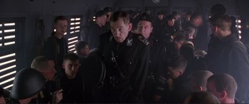 Movie still from “Richard III” (1995), directed by Richard Loncraine – A group of men in uniform are standing in a room; Medium shot, Low angle