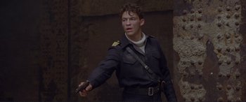Movie still from “Richard III” (1995), directed by Richard Loncraine – A man in a uniform holding a knife in his hand; Medium shot, Low angle