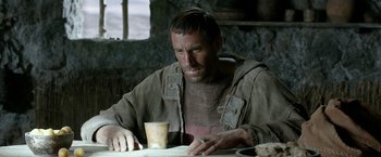 Movie still from “Risen” (2016), directed by Kevin Reynolds – A man sitting at a table with a cup of coffee; Close Up shot, Over the shoulder angle