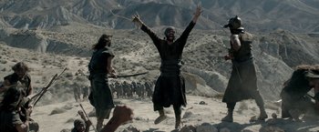 Movie still from “Risen” (2016), directed by Kevin Reynolds – A man is jumping up in the air while holding his hands in the air; Wide shot, Low angle