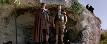Movie still from “Risen” (2016), directed by Kevin Reynolds – A couple of men standing next to each other; Medium shot, Low angle