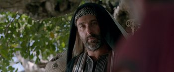 Movie still from “Risen” (2016), directed by Kevin Reynolds – A man with a beard wearing a headdress; Close Up shot, Over the shoulder angle