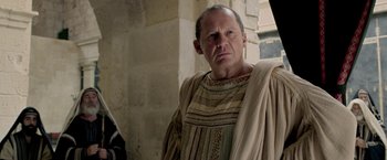 Movie still from “Risen” (2016), directed by Kevin Reynolds – A man in a roman outfit standing in front of a wall; Close Up shot, Over the shoulder angle