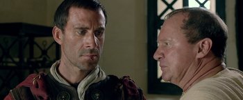 Movie still from “Risen” (2016), directed by Kevin Reynolds – A man and a man in medieval garb looking at one another; Close Up shot, Over the shoulder angle