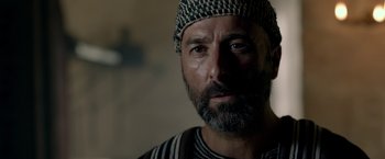 Movie still from “Risen” (2016), directed by Kevin Reynolds – A person with a beard wearing a hat; Close Up shot, Over the shoulder angle