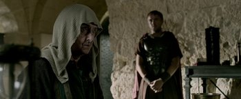 Movie still from “Risen” (2016), directed by Kevin Reynolds – Two men in roman garb standing next to each other; Medium shot, Over the shoulder angle