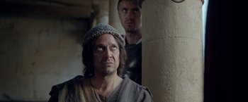 Movie still from “Risen” (2016), directed by Kevin Reynolds – A man with a beard and a hat is standing next to another man with a beard; Close Up shot, Over the shoulder angle