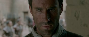 Movie still from “Risen” (2016), directed by Kevin Reynolds – A man's face with blood on his cheek; Close Up shot, Over the shoulder angle
