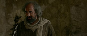 Movie still from “Risen” (2016), directed by Kevin Reynolds – A man with long hair and a beard wearing a scarf; Medium shot, Over the shoulder angle