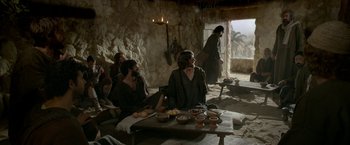 Movie still from “Risen” (2016), directed by Kevin Reynolds – A group of people sitting around a table with food on top of it; Wide shot, Over the shoulder angle